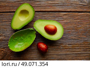avocado cut on aged wood table board cutted half. Стоковое фото, агентство Ingram Publishing / Фотобанк Лори