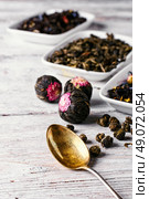 Several types of leaf tea light on a bright wooden background.. Flavored blooming tea. Стоковое фото, агентство Ingram Publishing / Фотобанк Лори