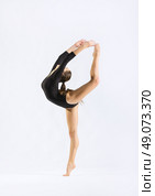 Young girl engaged art gymnastic on grey. Стоковое фото, агентство Ingram Publishing / Фотобанк Лори