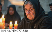 An elderly woman in a black chador lighting candles at dusk, their flickering glow reflecting in her grief-stricken eyes, surrounded by quiet reverence. Стоковое AI-видео, аниматор Sergey Grishin / Фотобанк Лори