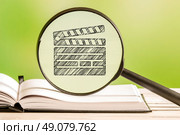 Video collection with a pencil drawing of a clapperboard in a magnifying glass. Стоковое фото, агентство Ingram Publishing / Фотобанк Лори