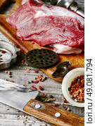 Cooking meat dish. Raw beef on chopping board and kitchen utensils. Стоковое фото, агентство Ingram Publishing / Фотобанк Лори
