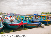 Traditional wooden Vietnamese boats on the Thu Bon River in the old town in Hoi An in Vietnam. Vietnam, Hoi An - December 1, 2024. Редакционное фото, фотограф Корчагина Анастасия / Фотобанк Лори
