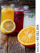 Freshly squeezed orange juice and citrus fruit in stylish glass jars. refreshing juice from fruits and aloe. Стоковое фото, агентство Ingram Publishing / Фотобанк Лори