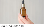 Female hands showing natural oil cosmetics on a Beige Background. Dropper amber brown glass Bottle with pipette. Spa Beauty products Isolate on Neutral Backdrop. Skincare recommend, makeup advertising. Стоковое видео, видеограф Марина Демидюк / Фотобанк Лори