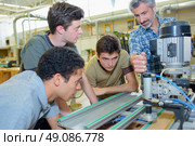 Apprentices learning to use machine. Стоковое фото, агентство Ingram Publishing / Фотобанк Лори