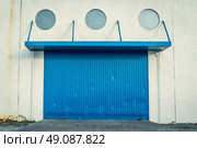 Blue gate on a grungy wall with round windows. Стоковое фото, агентство Ingram Publishing / Фотобанк Лори