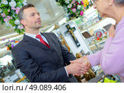 Funeral director shaking hands with elderly woman. Стоковое фото, агентство Ingram Publishing / Фотобанк Лори