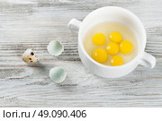 Quail egg yolks in a white plate on a wooden background. Стоковое фото, агентство Ingram Publishing / Фотобанк Лори