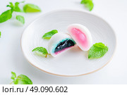 Delicious Japanese moti desserts. Close up. Asian rice daifuku dessert sweet mochi. Cut in half with filling. Traditional dessert mochi ice cream. Colorful rice cake. Fukashi manju. Culinary delights. Стоковое AI-изображение, AI-художник Марина Демидюк / Фотобанк Лори
