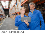 Man and woman looking at tablet in warehouse. Стоковое фото, агентство Ingram Publishing / Фотобанк Лори