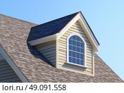 House Exterior. Roof Window. Second floor among blue sky. Mansard attic. Newly build houses. Gable roof with skylight, asphalt roofing, shingles. Residential Home. Vinyl Siding. Polymeric roof-tiles. Стоковое AI-изображение, AI-художник Марина Демидюк / Фотобанк Лори