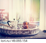 Espresso set with coffee cups, beans and coffee pot on sweet coffee on window sill  background. Стоковое фото, агентство Ingram Publishing / Фотобанк Лори