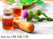 Flower and burdock extract. Buds wild plants burdock and burdocks medicinal tincture from it. Стоковое фото, агентство Ingram Publishing / Фотобанк Лори