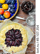 Pie with plums. Rustic pie with plums and plum jam on wooden background. Стоковое фото, агентство Ingram Publishing / Фотобанк Лори