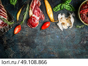 Italian antipasto snack with smoked meat, tomatoes and ciabatta bread on rustic background, top view, border. Стоковое фото, агентство Ingram Publishing / Фотобанк Лори