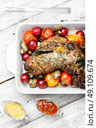Meatloaf in vegetables and fruits. Meat knuckle of beef in the baking dish with tomatoes and plum sauce. Стоковое фото, агентство Ingram Publishing / Фотобанк Лори