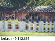 White picket fence in a garden with a woodshed. Стоковое фото, агентство Ingram Publishing / Фотобанк Лори
