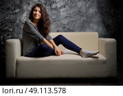 Portrait of young girl on sofa. Стоковое фото, агентство Ingram Publishing / Фотобанк Лори