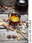 Mulled wine and spices. glass of mulled wine with almonds,cinnamon and anise on background of carafe of wine. Стоковое фото, агентство Ingram Publishing / Фотобанк Лори
