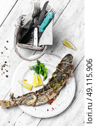 grill fish on light plate. whole carcass of fish grilled on light plate on light background. Стоковое фото, агентство Ingram Publishing / Фотобанк Лори