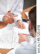 Two men discussing blueprints. Стоковое фото, агентство Ingram Publishing / Фотобанк Лори
