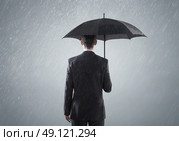 Young smart busienssman standing in the heavy rain. Стоковое фото, агентство Ingram Publishing / Фотобанк Лори
