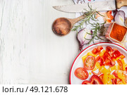 Cut vegetables , flavoring  and herbs with cooking wooden spoon and kitchen knife on white wooden background, top view, border.  Healthy and vegetarian food or diet nutrition concept. Стоковое фото, агентство Ingram Publishing / Фотобанк Лори