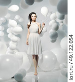 Cute young woman among numerous white balloons. Стоковое фото, агентство Ingram Publishing / Фотобанк Лори