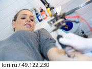 putting on a tattoo. Стоковое фото, агентство Ingram Publishing / Фотобанк Лори
