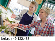 seller helping woman purchasing fish in supermarket. Стоковое фото, агентство Ingram Publishing / Фотобанк Лори