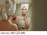Blond woman rubbing gently a moisturising cream. Стоковое фото, агентство Ingram Publishing / Фотобанк Лори