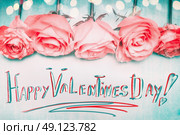 Happy Valentines Day greeting, handwritten,  with pink roses and bokeh on blue backgound. Стоковое фото, агентство Ingram Publishing / Фотобанк Лори