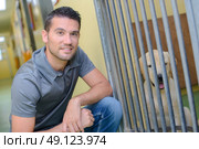 Man next to dog in kennel. Стоковое фото, агентство Ingram Publishing / Фотобанк Лори