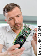Computer specialist looking at a video card. Стоковое фото, агентство Ingram Publishing / Фотобанк Лори