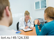 smily young female doctor giving results to patients. Стоковое фото, агентство Ingram Publishing / Фотобанк Лори