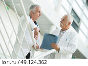 Senior workers in discussion on staircase. Стоковое фото, агентство Ingram Publishing / Фотобанк Лори