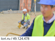 builders using measuring tools outdoors in a construction site. Стоковое фото, агентство Ingram Publishing / Фотобанк Лори
