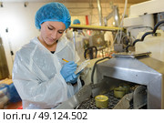 Female factory operative watching production line. Стоковое фото, агентство Ingram Publishing / Фотобанк Лори