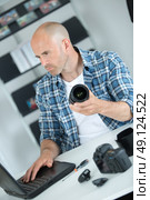 male middle-aged photographer sitting on the desk with laptop. Стоковое фото, агентство Ingram Publishing / Фотобанк Лори