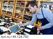 wine seller man tidying up bottles. Стоковое фото, агентство Ingram Publishing / Фотобанк Лори