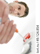 Electrician repairing a wall socket. Стоковое фото, агентство Ingram Publishing / Фотобанк Лори