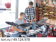 Young men looking at electronic drum kit. Стоковое фото, агентство Ingram Publishing / Фотобанк Лори