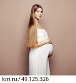 Portrait of the young pregnant woman. Pregnancy, love, people and expectation concept. Happy pregnant lady with long hair. Стоковое фото, агентство Ingram Publishing / Фотобанк Лори