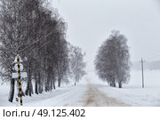 Snowfall and sleet on winter road. Ice snowy road. Winter snowstorm. Black ice and blizzard. Стоковое фото, агентство Ingram Publishing / Фотобанк Лори