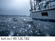 A boat is in the water with rain falling on it. Стоковое AI-изображение, AI-художник Ярославский Максим / Фотобанк Лори