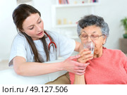 Giving senior woman a drink of water. Стоковое фото, агентство Ingram Publishing / Фотобанк Лори