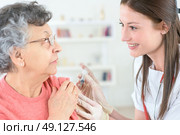 doctor inject influenza vaccine into old woman patient. Стоковое фото, агентство Ingram Publishing / Фотобанк Лори
