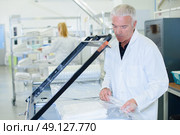 Man shrink wrapping clean laundry. Стоковое фото, агентство Ingram Publishing / Фотобанк Лори