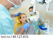 dentist curing a woman patient in the dental office. Стоковое фото, агентство Ingram Publishing / Фотобанк Лори